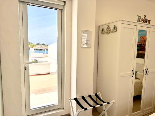 a room with a window and a chair next to a door at Torre Pozzillo Beach in Cinisi