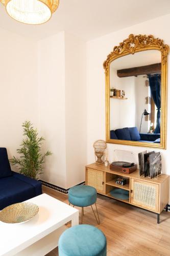 a living room with a mirror and a couch at Le rêve bleu in Moulins
