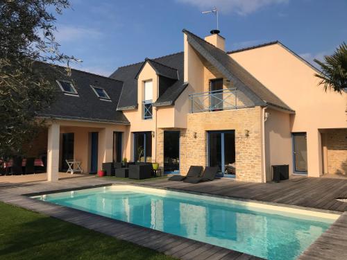 une maison avec une piscine devant une maison dans l'établissement L'océane, au Pouliguen