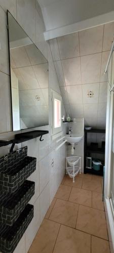 La salle de bains est pourvue d'un lavabo et d'un porte-parole. dans l'établissement Maison Batz sur Mer Presqu'île de Guérande, à Batz-sur-Mer