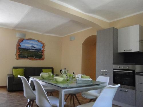 uma sala de jantar com uma mesa e cadeiras brancas em Di-vinodormire em La Morra