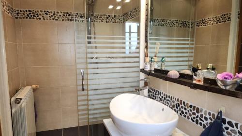 une salle de bain avec un lavabo blanc et une douche dans l'établissement Villa de standing avec piscine à débordement, jacuzzi et jardin à 5 min du centre de Nîmes, à Nîmes