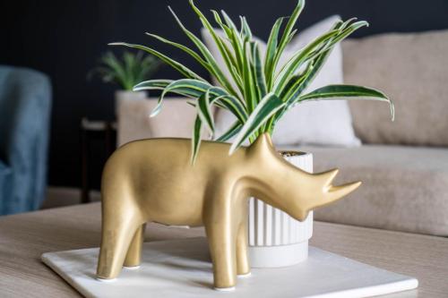 a gold statue of a deer on a table with a potted plant at The Greensboro Vibe 8715 in Friendship