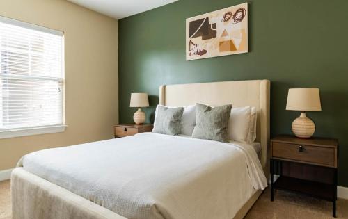 a bedroom with a white bed and green walls at The Greensboro Vibe 8715 in Friendship