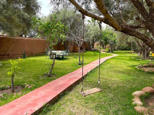 a swing hanging from a tree in a yard at Palais Julia in Chouiter