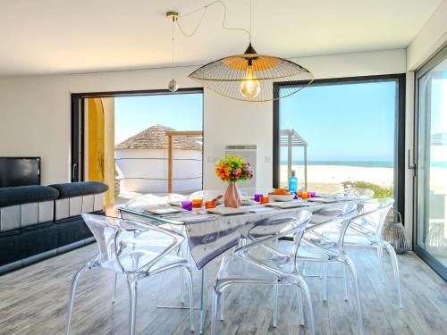 une salle à manger avec une table et des chaises avec vue sur l'océan dans l'établissement Holiday Home La Dune des ailes by Interhome, à Mimizan