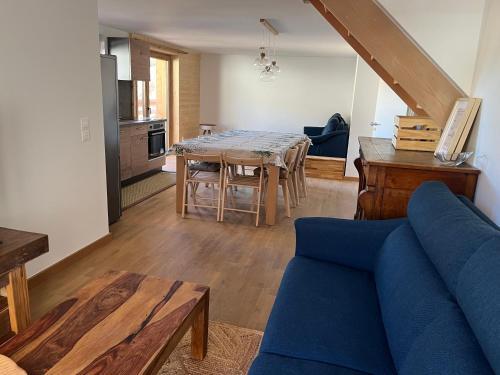 un salon avec un canapé bleu et une table dans l'établissement AO Duplex 82 m2, à Vars