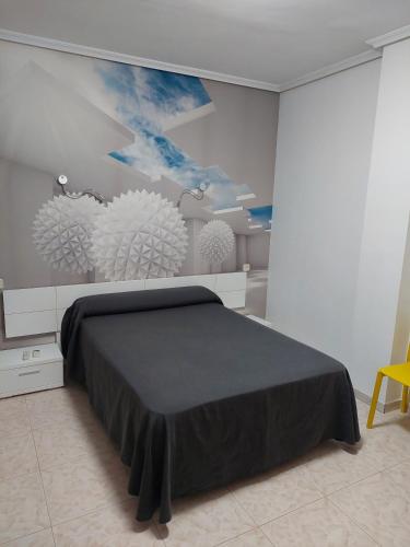 a bedroom with a bed and a painting on the wall at Hotel Cervantes in Mahora