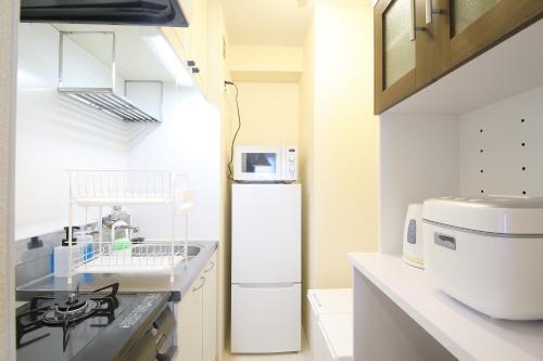 a kitchen with a sink and a refrigerator at ノーザンヒルズ南6条 in Sapporo