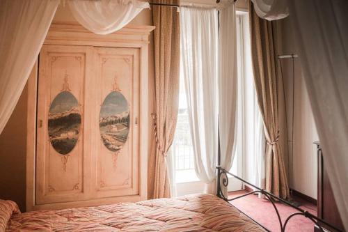 a bedroom with a bed and a large window at Albergo Olivo in Belluno Veronese