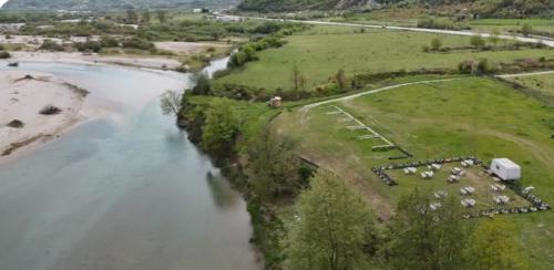 an aerial view of a river with a farm at Camping Shtepez in Gjirokastër