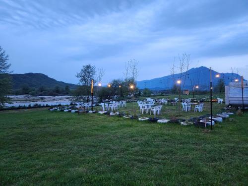 a group of white chairs in a field at Camping Shtepez in Gjirokastër