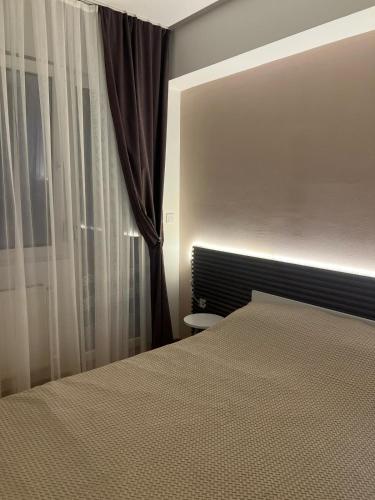 a bedroom with a bed and a window with curtains at Cozy Studio Near Downtown in Skopje