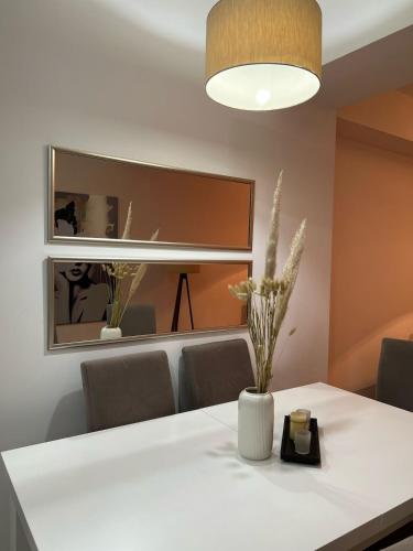 a dining room with a white table and a mirror at Cozy Studio Near Downtown in Skopje