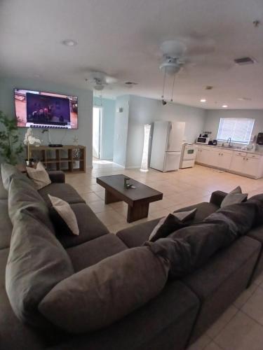 een grote bruine bank in een woonkamer met een tafel bij 4 BR 2 BA Near the Beach and Intracoastal Walk to everything in Riviera Beach