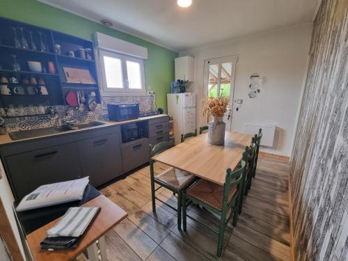 une cuisine avec une table en bois et une table et des chaises dans l'établissement Le Petit Jean, à La Vernelle