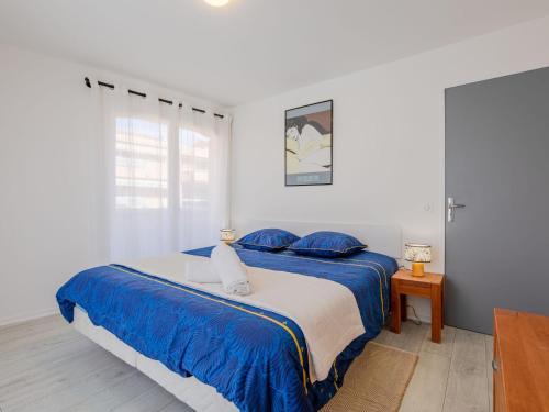 - une chambre blanche avec un lit bleu et des oreillers bleus dans l'établissement Apartment Le Christina by Interhome, à Sainte-Maxime