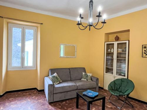 a living room with a couch and a chandelier at Apartment Giove by Interhome in Valloria