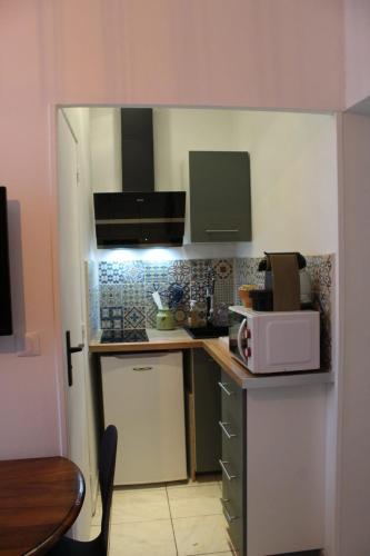 une petite cuisine avec un comptoir et un four micro-ondes dans l'établissement Au coeur de Boutonnet, à Montpellier