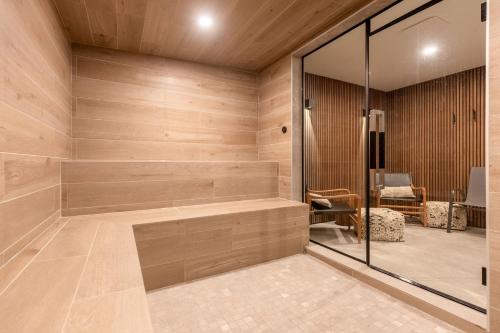 a sauna with wooden walls and a glass door at The Alders Chalet by Fernie Central Reservations in Fernie