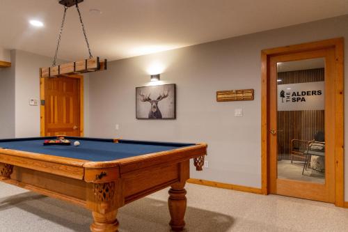 a room with a pool table in a room with a door at The Alders Chalet by Fernie Central Reservations in Fernie