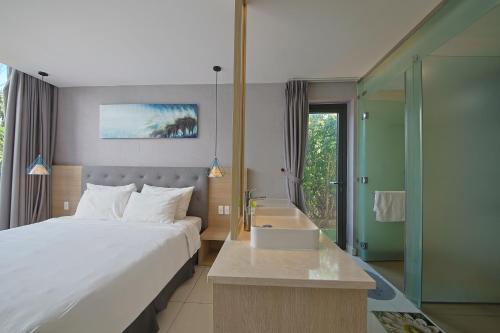 a bedroom with a bed and a bathroom with a sink at Nguyen Le Villa Long Hải in Long Hai