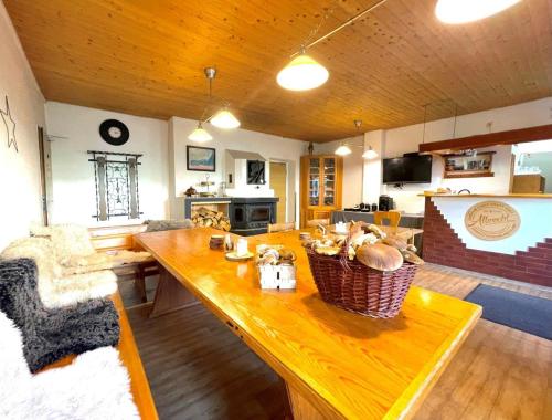 a living room with a wooden table and a kitchen at Horská chata WALTEROVKA in Josefuv dul