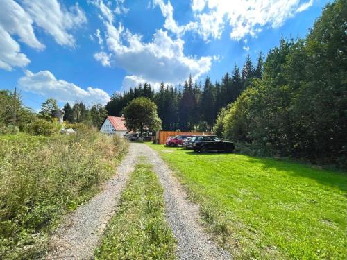 a dirt road with cars parked in a field at Horská chata WALTEROVKA in Josefuv dul
