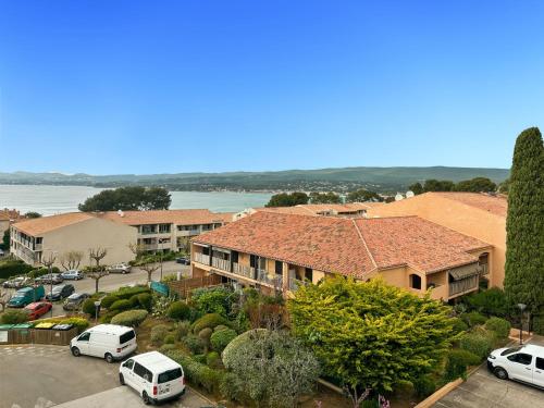une vue aérienne sur une maison avec des voitures garées sur un parking dans l'établissement Studio Les Aigues Marines-74 by Interhome, à Saint-Cyr-sur-Mer