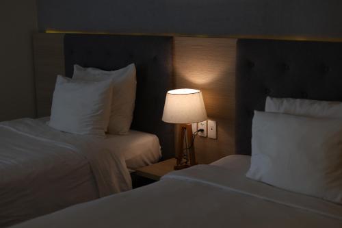 a hotel room with two beds and a lamp at Nguyen Le Villa Long Hải in Long Hai