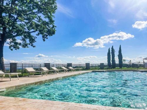 a swimming pool with chairs and trees and a blue sky at Apartment La Bordona by Interhome in Vignale Monferrato