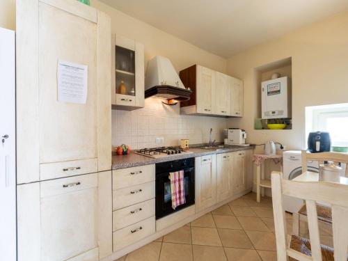 a kitchen with white cabinets and a stove top oven at Apartment La Bordona by Interhome in Vignale Monferrato