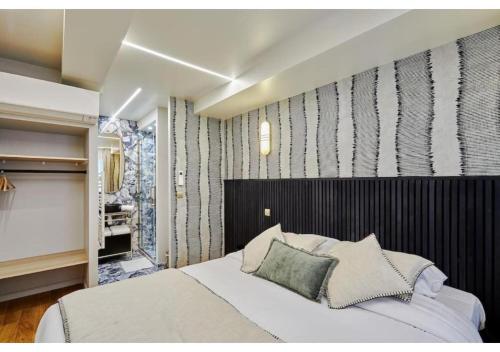 une chambre avec un grand lit et une salle de bain dans l'établissement Apartment Le Marais place des Vosges by Studio prestige, à Paris