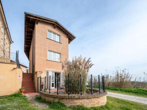 a brick house with a fence in front of it at Apartment La Bordona by Interhome in Vignale Monferrato