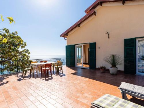 a patio with a table and chairs and the ocean at Holiday Home Casa Cycas by Interhome in Ospedaletti