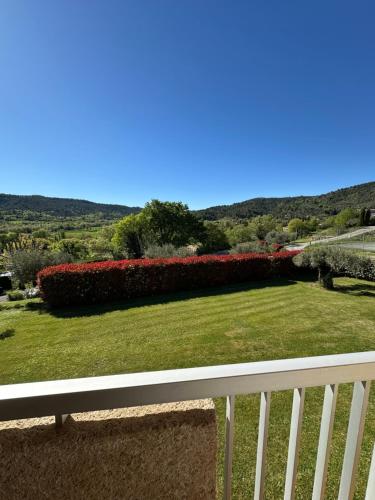 a view of a garden with a bench on a balcony at Hôtel Le Colombier in Moustiers-Sainte-Marie
