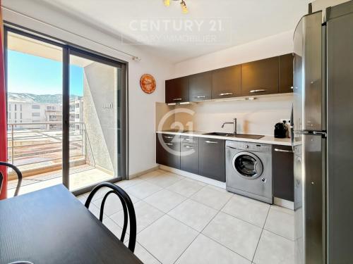 Cet appartement comprend une cuisine équipée d'un lave-linge et d'un sèche-linge. dans l'établissement Résidence Grand Large - Appartement T3 proche de la plage de Calvi, à Calvi