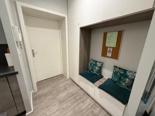 a hallway with two green pillows and a door at LE MUSCAT in Colmar