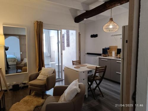 un salon avec une table et des chaises et une cuisine dans l'établissement Pleasant apartment in Bormes Village, à Bormes-les-Mimosas