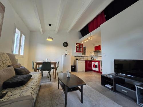 un salon avec un canapé et une table dans l'établissement Joli appartement T2 cabine avec parking et wifi Tennis Village, au Cap d'Agde