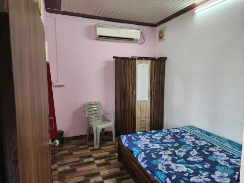 Un dormitorio con una cama y una silla en una habitación. en Nandanvan sanskruti farm karjat, en Karjat