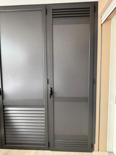 two sliding glass doors in a room at Penthouse Apartment A due passi dal Mare in Alghero