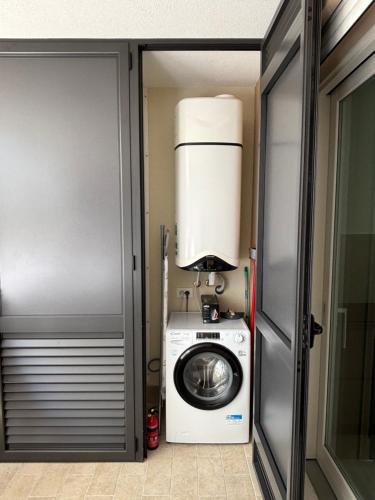 a washer and dryer in a room next to a door at Penthouse Apartment A due passi dal Mare in Alghero