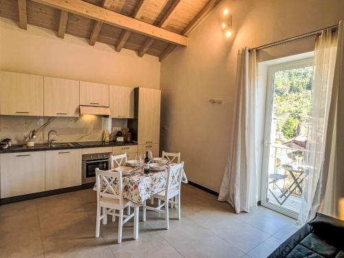 a kitchen with a table with white chairs and a window at Holiday Home La casa di Anna by Interhome in Dolcedo
