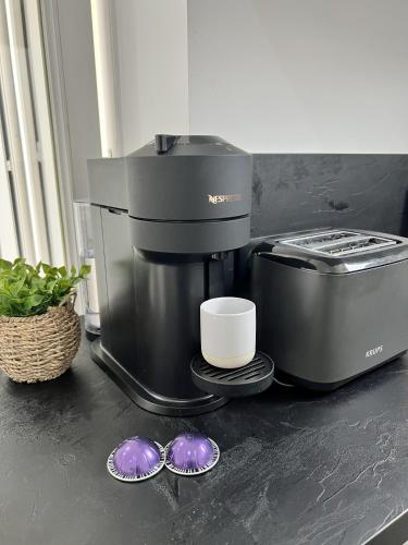 une cafetière assise sur un comptoir avec deux tasses dans l'établissement Studio centre ville de Nice à 200m de la plage, à Nice