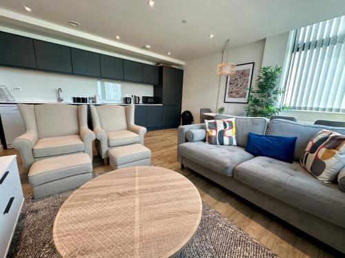 a living room with a couch and two chairs and a table at Lovely 1 Bed Apartment - Old Trafford in Manchester