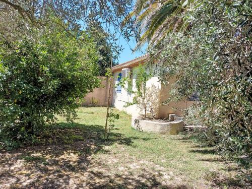 a yard with trees and a house with a fence at Holiday Home Mas des Lavandes by Interhome in Graveson