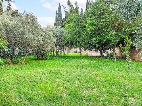 a field of green grass with trees in the background at Holiday Home Mas des Lavandes by Interhome in Graveson