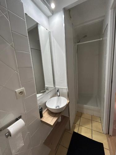 une salle de bain blanche avec un lavabo et une douche dans l'établissement Appartement rénové à 50 m de COLLIOURE Plage, Entrée autonome, Climatisé, à Collioure