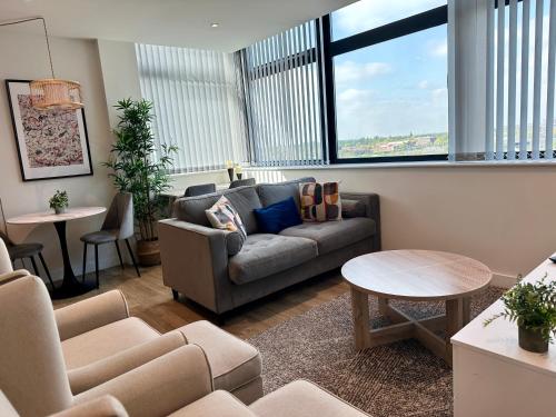 a living room with a couch and a table at Lovely 1 Bed Apartment - Old Trafford in Manchester